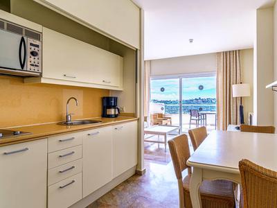 Small modern kitchen with dining area and sea view balcony in the vacation apartment