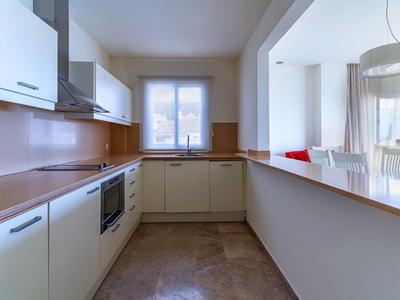 Modern, bright kitchen with white cabinets and wood countertops in an open space.