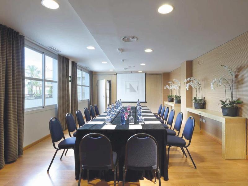 Conference room with a long table surrounded by chairs and large windows.