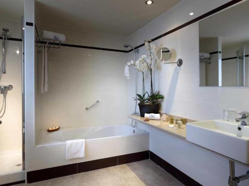 Modern bathroom with shower, bathtub, sink, and large mirror.