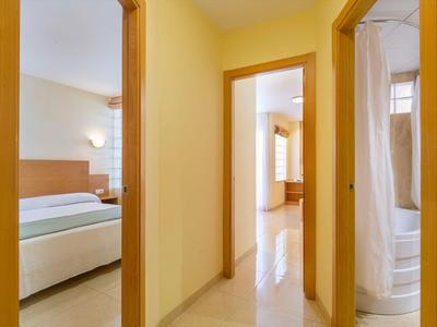 Hallway with views into bedroom and bathroom in a bright hotel room