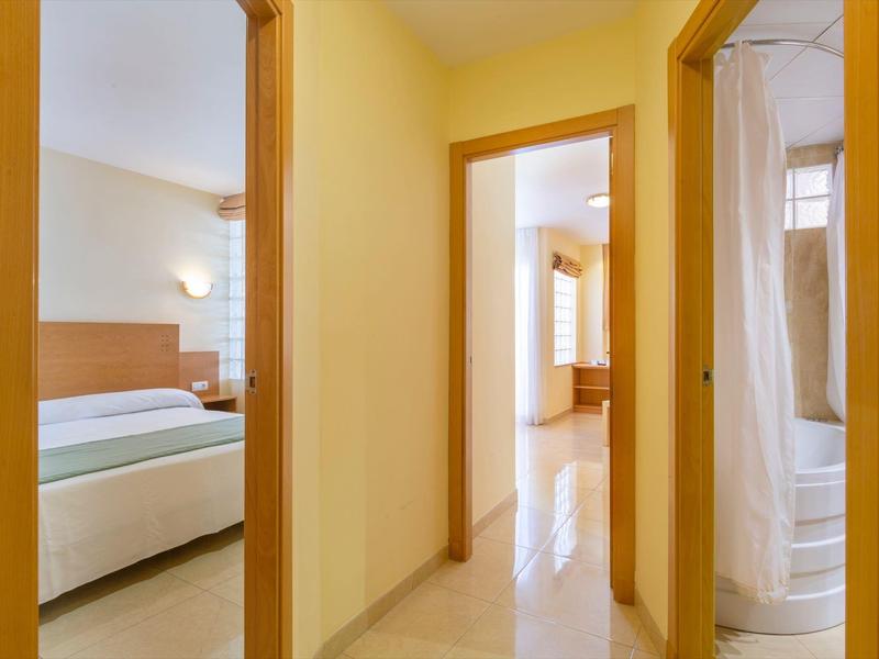 Hallway with views into bedroom and bathroom in a bright hotel room