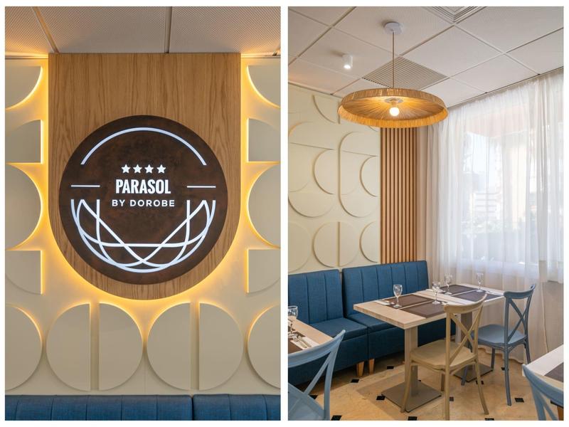 Cozy restaurant with blue benches, wooden tables, and modern lighting.