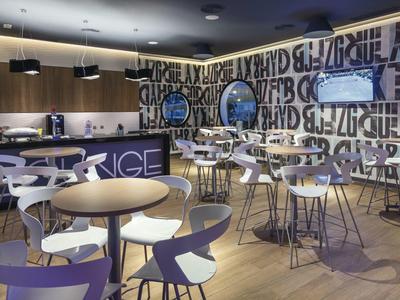 Sala da pranzo moderna con tavoli rotondi e sedie bianche in un ambiente elegante.