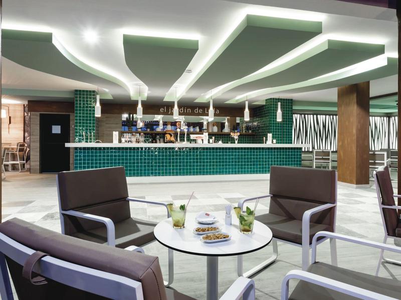 Interno moderno di un bar con sedute comode e illuminazione elegante.