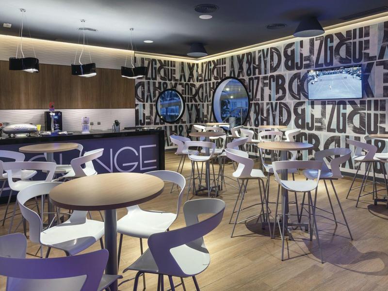 Sala da pranzo moderna con tavoli rotondi e sedie bianche in un ambiente elegante.