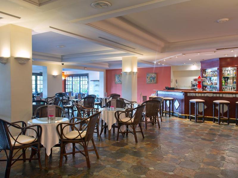 Bar confortable avec tables, chaises et comptoir éclairé dans un hôtel.