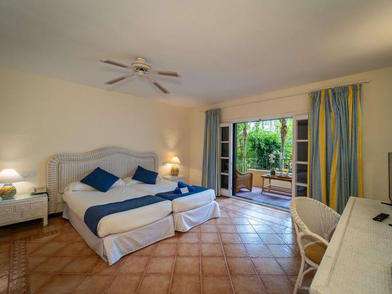 Chambre d'hôtel lumineuse avec lit double, nouveau carrelage et accès à la terrasse.