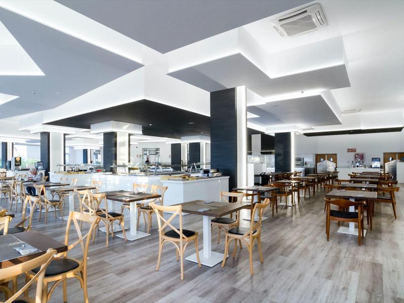 Bright, modern restaurant with white walls, wooden floors, and minimalist furniture.