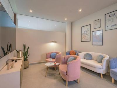Gemütlicher Hotel-Warteraum mit Sofas, Sesseln und moderner Beleuchtung.