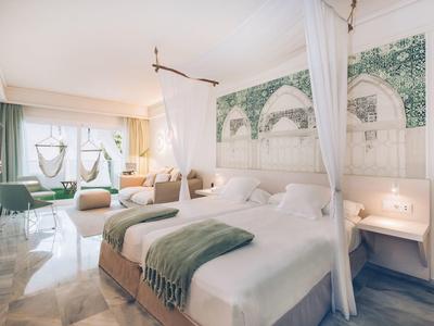 Helles Doppelzimmer mit Himmelbett, Marmorboden und großem Fenster mit Vorhängen.