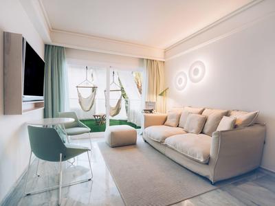 Helles, modernes Wohnzimmer mit gemütlichem Sofa, zwei Sesseln und großem Fenster mit grünen Vorhängen.