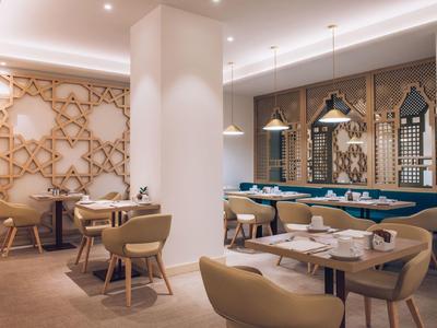 Moderner Hotel-restaurantbereich mit bequemen sesseln und dekorativen holzelementen an der wand.