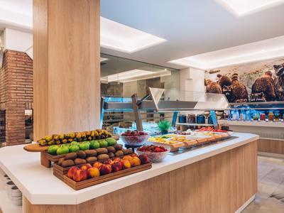 Buffet mit frischem Obst und vielfältigen Speisen in modern gestaltetem Hotelrestaurant.