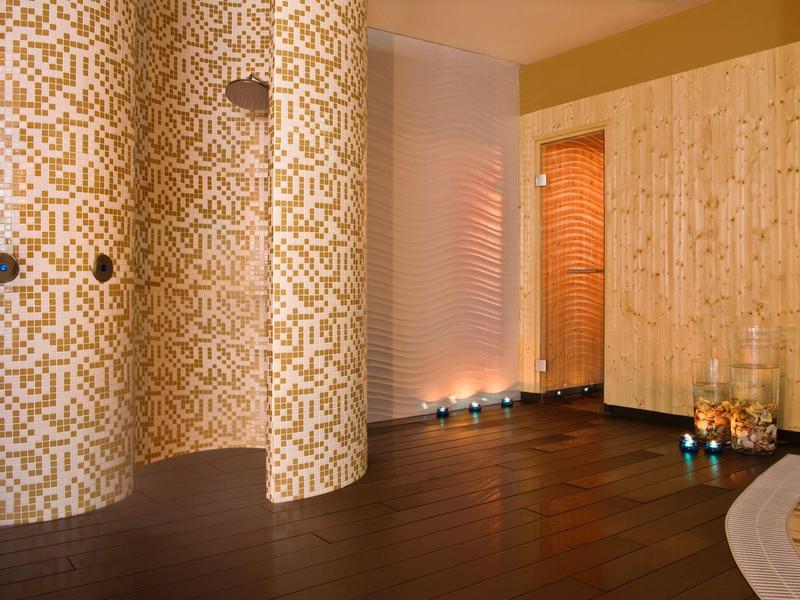 Modern spa area with round columns, ambient lighting, and wooden flooring.