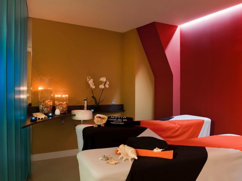 Cozy spa room with two beds, candlelight, and a relaxing ambiance.