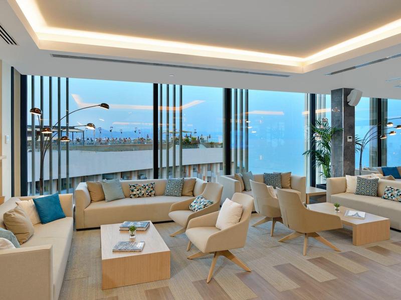 Modern lounge area with large windows and sea view.