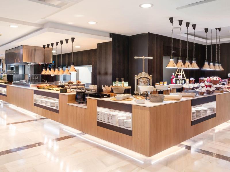 Modern, bright buffet with wooden fronts and a variety of food in a hotel restaurant.