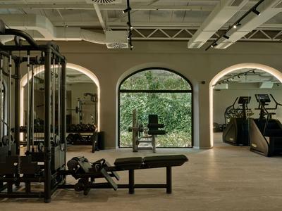 Palestra moderna con grandi finestre e varie attrezzature per l'allenamento.