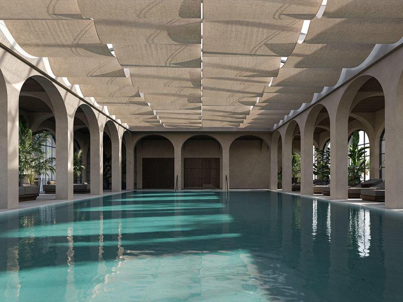 Piscina cubierta amplia con altos arcos y luz que entra desde el techo.