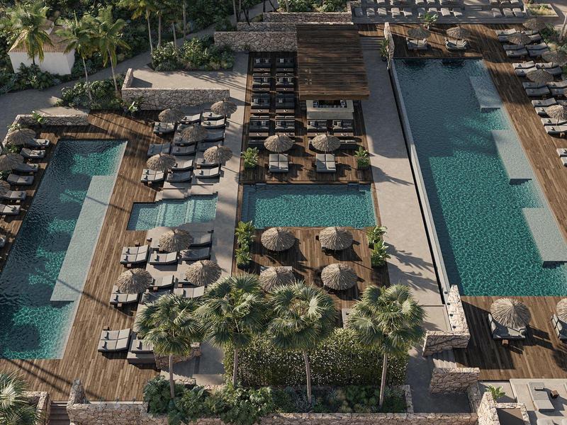 Vista de dos piscinas paralelas con tumbonas y sombrillas en un entorno hotelero.