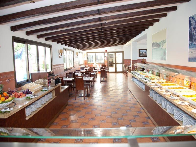 Bright dining room with rustic wood decor and buffet featuring various dishes.