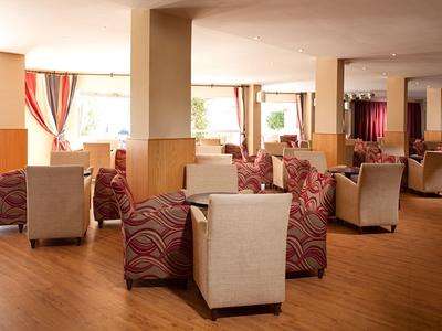 Großer Lounge-Bereich mit gepolsterten Sesseln und Holzfußboden in einem Hotel.