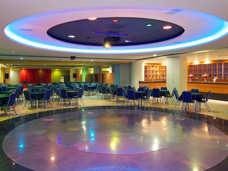 Ein modernes Badezimmer mit Badewanne, großem Spiegel, Waschbecken und weißen Handtüchern an Wänden.