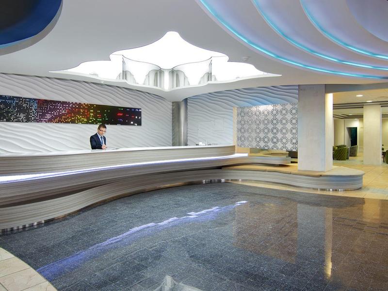 Moderner Empfangsbereich mit geschwungener Theke, blauem LED-Licht und offenem, heller Raum.