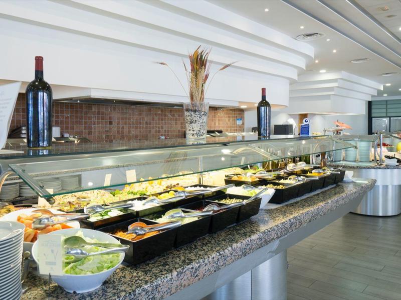 Großer Buffetbereich mit vielfältigen Speisen, Getränken und sauber gestapeltem Geschirr.
