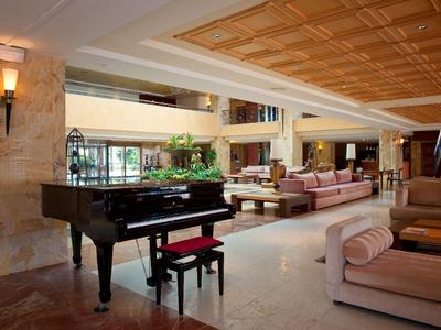 Hotel-Lobby mit Flügel, bequemen Sofas und moderner, heller Einrichtung.