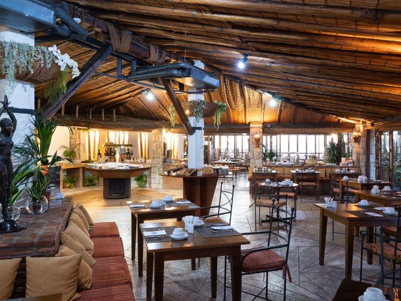 Gemütliches Restaurant mit Holzbalkendecke, warmem Licht und rustikalen Holzmöbeln.