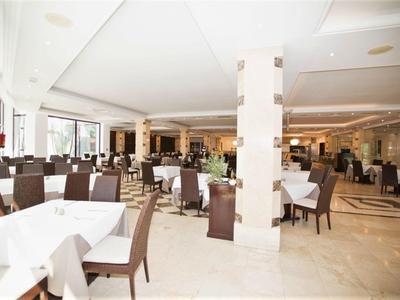 Heller und eleganter Speisesaal mit gedeckten Tischen und braunen Stühlen in einem Hotel.