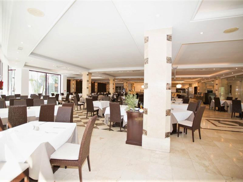 Heller und eleganter Speisesaal mit gedeckten Tischen und braunen Stühlen in einem Hotel.