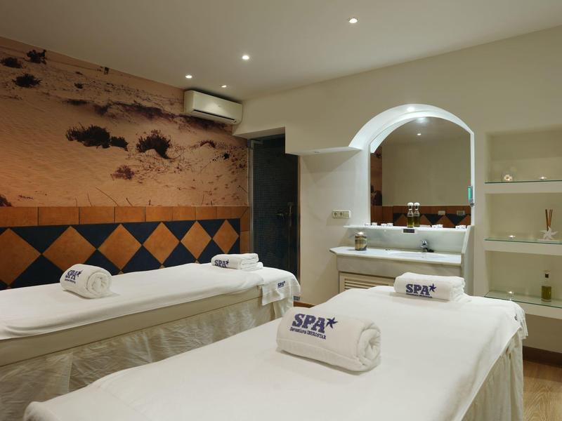 Zwei bequeme Massageliegen mit weißen Handtüchern in einem ruhigen, modern eingerichteten Raum.