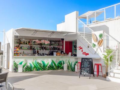 Moderner weißer Außenbarbereich mit grünen Pflanzen und Treppe unter blauem Himmel