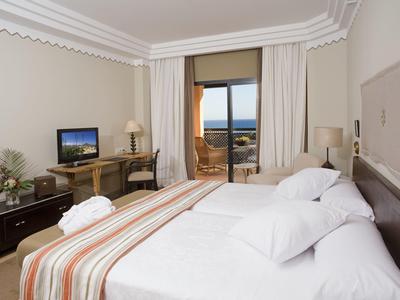 Gemütliches Schlafzimmer mit Doppelbett, Schreibtisch, TV und Balkon mit Meerblick.