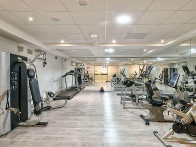 Palestra moderna con varie attrezzature per esercizi e illuminazione brillante