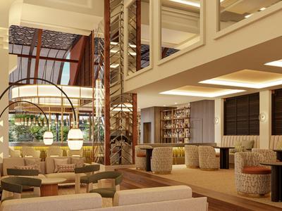 Großer, eleganter Hotel-Lobby-Bereich mit bequemen Sofas, Holzakzenten und warmem Licht.