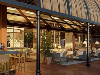 Gemütliche Außenterrasse eines Hotels mit Tischen, Stühlen und Pflanzen bei Dämmerung.