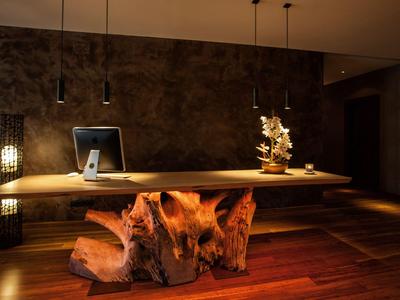 Eleganter Empfangstresen aus Holz mit warmem Licht und moderner Dekoration.