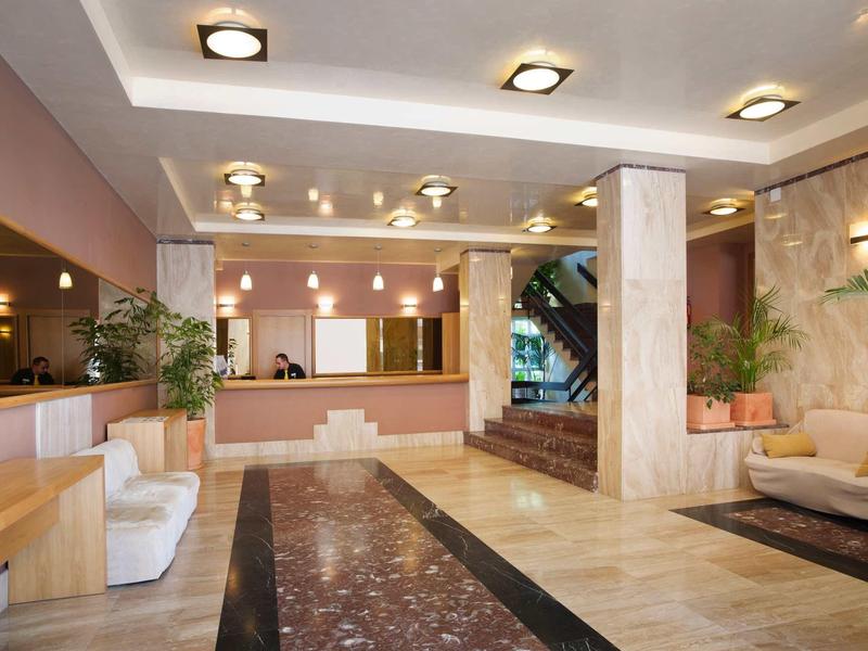 Moderne helle Lobby mit beigem Marmor, Sitzgelegenheiten und Deckenlampen.