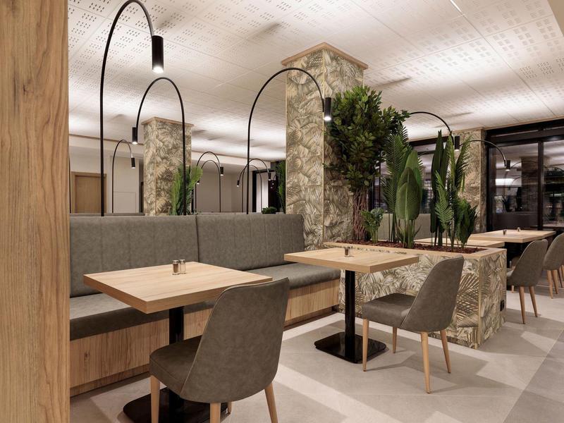 Modernes Café mit holzfarbenen Tischen, grauen Stühlen und Steinwänden, dekoriert mit Pflanzen.