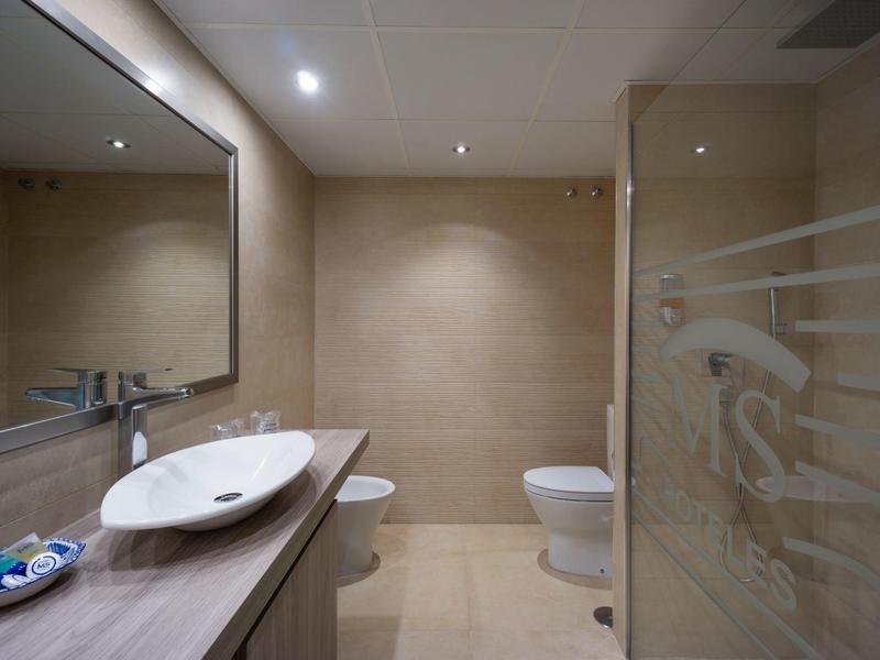 Modernes Badezimmer mit Waschbecken, Toilette und Duschkabine in einem Hotelzimmer.