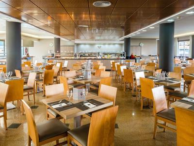 Großer, heller Speisesaal mit zahlreichen Holzstühlen und Tischen, modern eingerichtet.