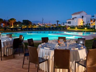 Abendliche Poolparty mit gedeckten Tischen und moderner Beleuchtung in warmem Ambiente.