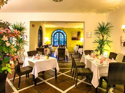 Gemütliches Restaurant mit gedeckten Tischen, Blumenarrangements und warmem Licht.