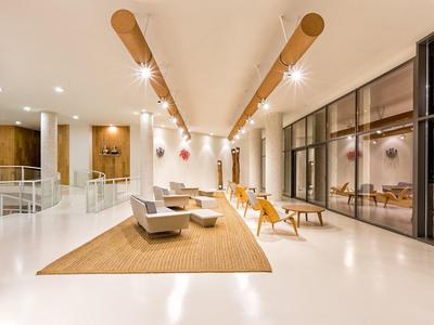 Moderner, heller Aufenthaltsraum mit bequemen Sesseln und großen Fenstern.