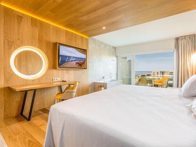 Modernes Hotelzimmer mit Doppelbett, Holzwand, Schreibtisch und Blick auf die Stadt