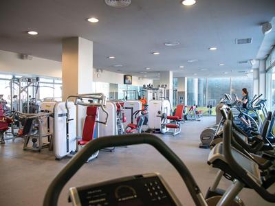 Gimnasio luminoso con máquinas de ejercicio y cintas de correr en un hotel.